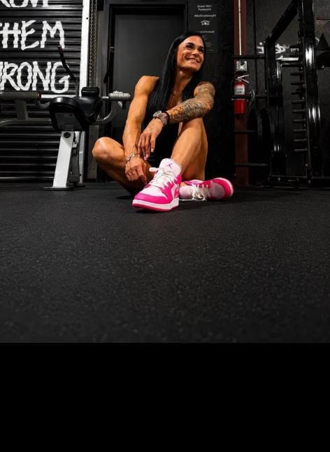 Michaela resting in the gym, Prove Them Wrong signage